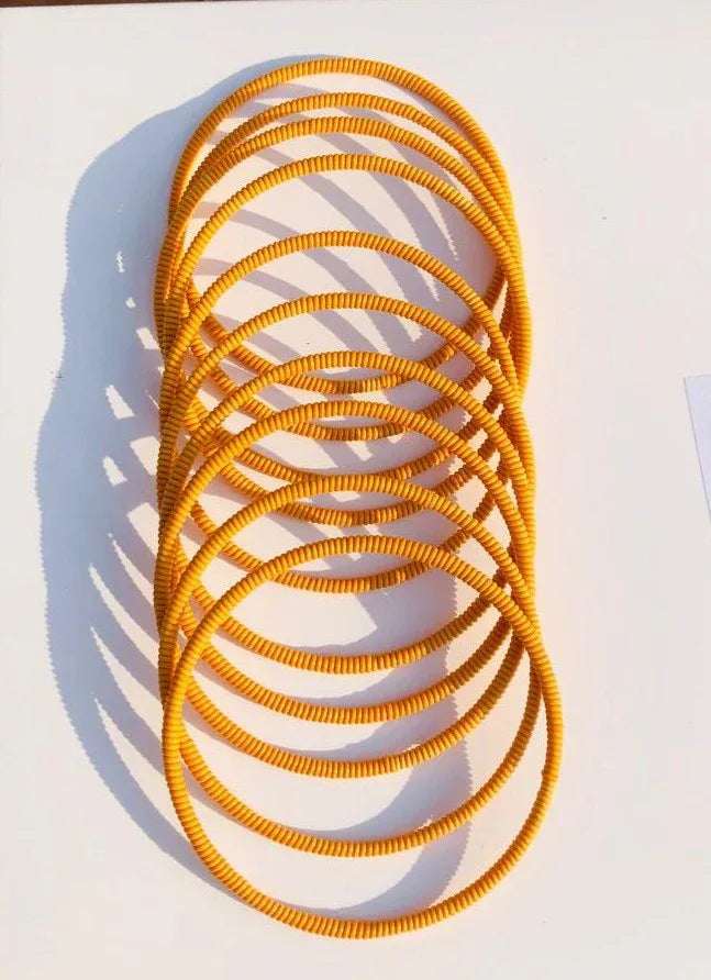 Venda Bangles – Multicolour Plastic-Wrapped Bracelets in bright yellow. Aluminium core bangles perfect for stacking and African heritage fashion.