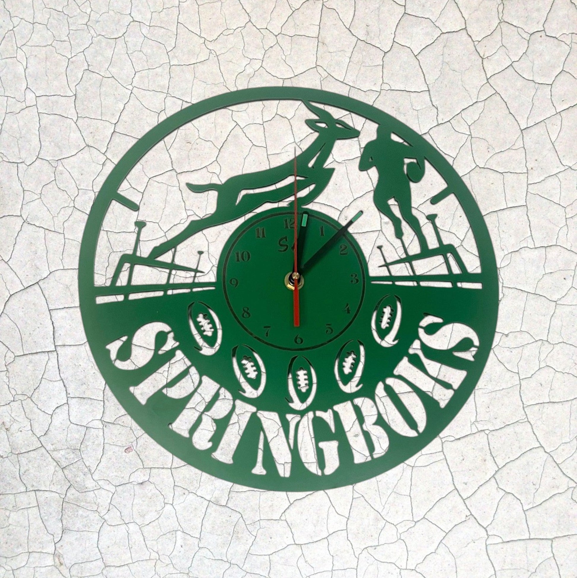 Green clock with 'Springboks' design on a white cracked surface