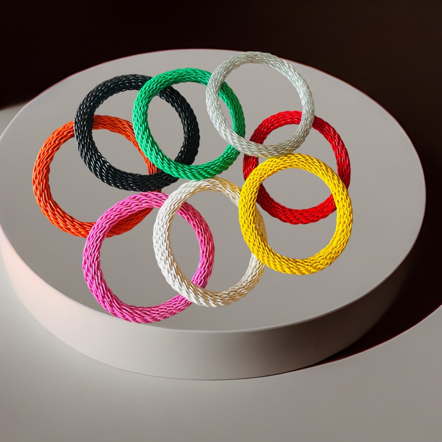 Colorful braided bracelets on a white platform