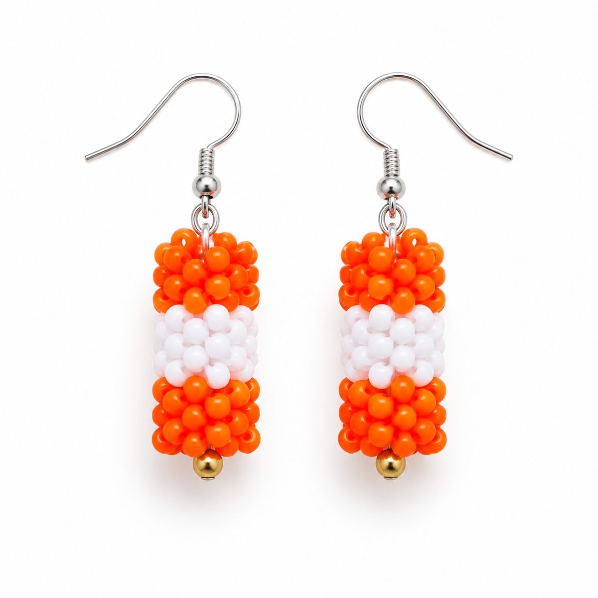 Short Orange & White plastic snowflake bead earrings on white background